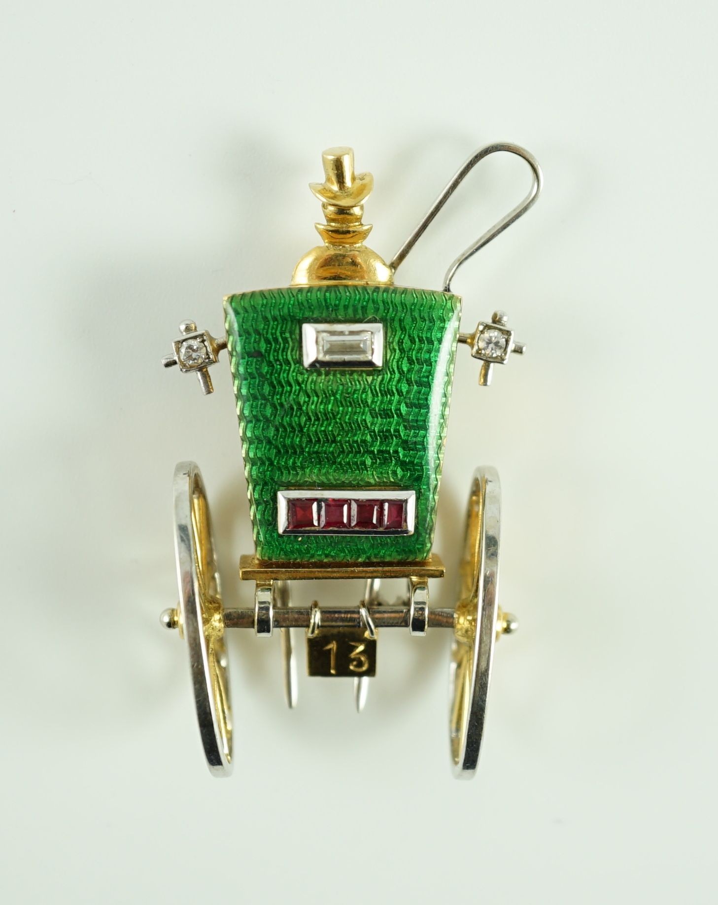 A mid 20th century Italian two colour 18ct gold, green enamel, ruby and diamond set novelty clip brooch, modelled as the rear view of a carriage with driver